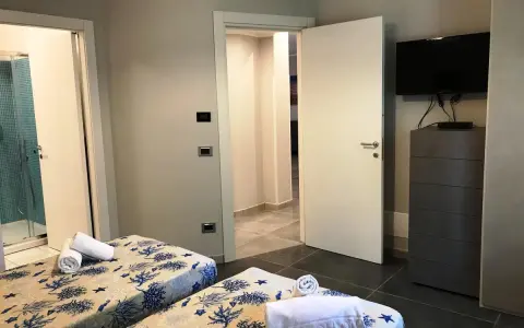 Camere con letti gemelli, biancheria a tema marino, bagno con doccia e TV. Un vero eden capo vaticano.