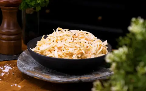 En skål med krämig, godaste coleslaw, toppad med peppar. Perfekt tillbehör!