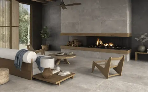 Salón moderno con chimenea encendida, sofá blanco y suelo de cemento pulido.