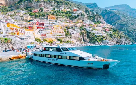 Il Positano Jet attracca al molo, con le case colorate della Costiera Amalfitana sullo sfondo.