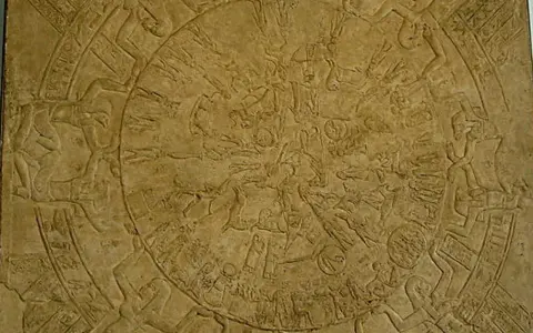 Bas-relief circulaire du zodiaque de Dendérah, représentant des figures mythologiques et des constellations dans un style égyptien ancien.