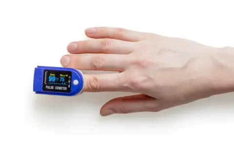 Fingerspitze mit Pulsoximeter, das den Puls beim Spazieren misst.