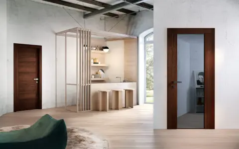 Porta in legno wenge colore, con maniglia in metallo, in un ambiente moderno con cucina a vista e pouf verde.