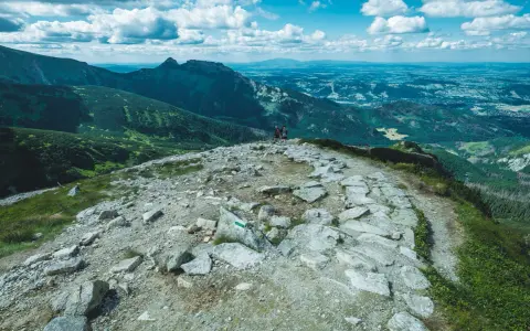 Kamienista ścieżka na szlak na Kasprowy Wierch z Kuźnic. W oddali widać góry i doliny.