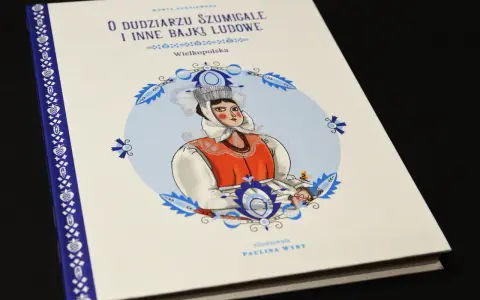 Okładka książki "O dudziarzu szumigale i inne bajki ludowe" z Wielkopolski. Ilustracja przedstawia kobietę w tradycyjnym stroju, jakby opowiadającą historie z tego słownika polskiej bajki ludowej.
