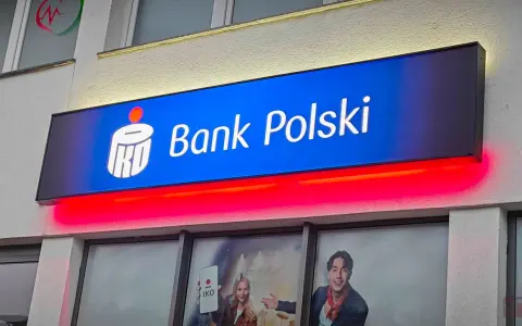 Reklama PKO Bank Polski z hasłem "kiedy nowe lokaty w pko bp". Jasny neon z logo banku i czerwone podświetlenie.