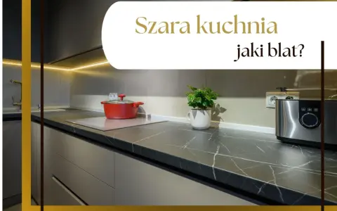 Nowoczesna szara kuchnia z ciemnym blatem, na którym stoi czerwony garnek i srebrny toster.