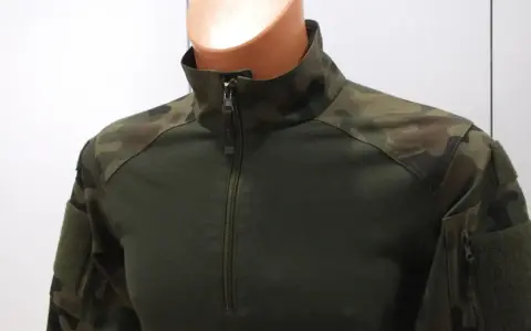Zielona bluza combat z kamuflażem na ramionach i rękawach. Zapinana na zamek.