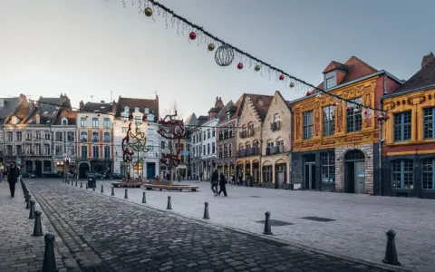 La Place du Théâtre à Lille, ornée de décorations de Noël, révèle les plus belles rues du Vieux-Lille avec ses façades colorées et pavées.