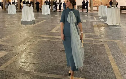 Elegante mujer con vestido azul claro y velo, lista para los Premios Princesa de Asturias.