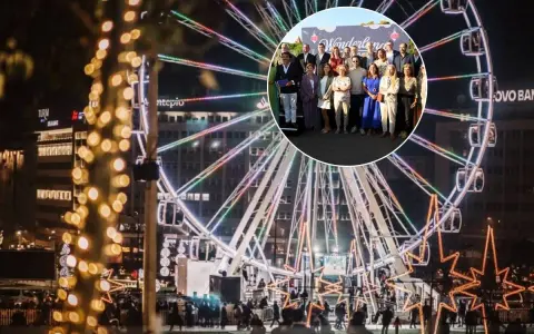 Eine Gruppe feiert bei Wonderland Lisboa vor einem beleuchteten Riesenrad.