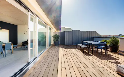 Modernes Einfamilienhaus mit großzügiger dachterrasse. Holzboden, Sitzgruppe und Pflanzen laden zum Verweilen ein.