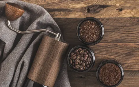 Holz-Kaffeemühle mit drei Behältern: ganze Bohnen, grob gemahlener und feiner, kleiner brauner Kaffee.