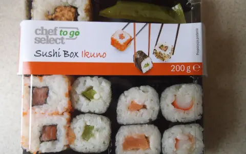Pudełko z **lidl sushi** Chef to Go Select Ikuno, zawiera różne rodzaje rolek z łososiem, awokado i krewetkami.
