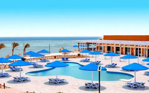 Basen z niebieskimi parasolami i leżakami, widok na morze. Idealne miejsce na wakacje, jak w Pickalbatros Portofino Marsa Alam.