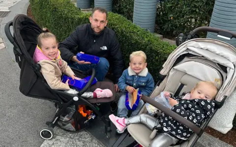 Familie genießt Snacks, um Disneyland Paris Essen mitzunehmen. Kinder in Kinderwagen und Vater mit Boxen.