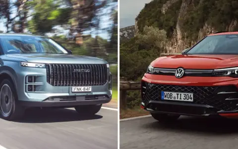 Dwa SUV-y na drodze: szary z pionową atrapą i czerwony Volkswagen SUV z charakterystycznym logo.