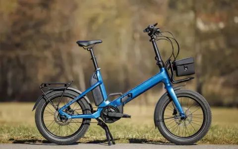 Blaues Cube Fold Hybrid 500 E-Bike im Test, mit Gepäckträger und Tasche.