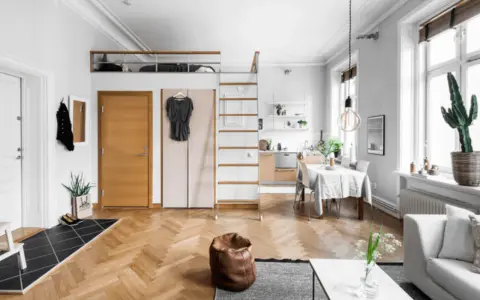 Smart compact living med loftssäng, kök och matplats. Enkla linjer och ljusa färger skapar rymd.
