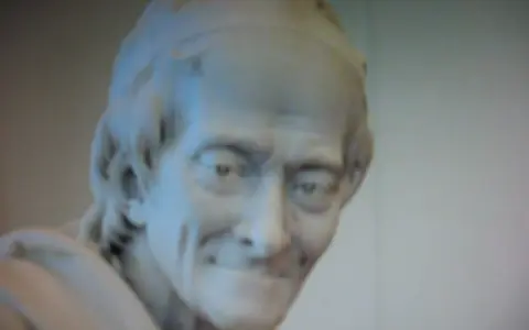 Buste en marbre d'un homme au sourire énigmatique, œuvre de Jean-Antoine Houdon.