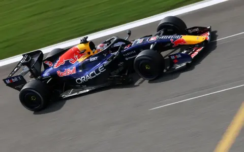 Coche de Red Bull Racing en plena carrera, con el logo del toro rojo y patrocinadores visibles.