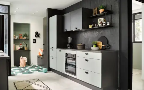 Cuisines vertes modernes avec murs texturés sombres, armoires claires et un coin bureau coloré.