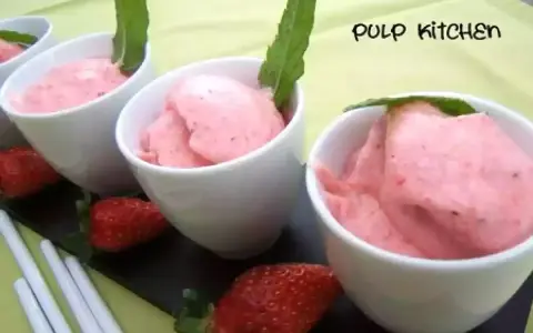 Délicieuse mousse fraise dans des coupelles blanches, garnie de menthe. Fraises fraîches et bâtonnets complètent cette gourmandise.