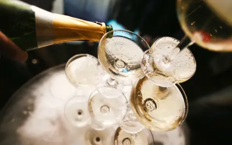 Champagner wird in Gläser gegossen, ein Moment, der die Champagner Geschichte feiert.