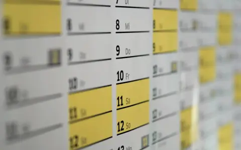 Zbliżenie na kalendarz z zaznaczonymi dniami, idealny do planowania wniosku o urlop wypoczynkowy.
