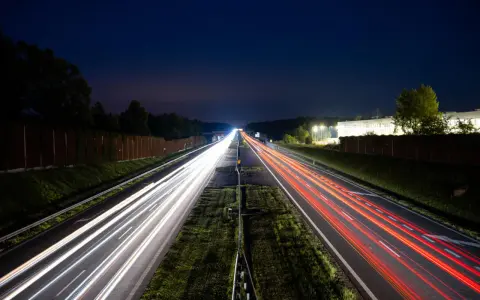 Nocne smugi świateł samochodów na autostradzie A4 między Katowicami a Krakowem. Opłaty za przejazd nie zatrzymują ruchu.