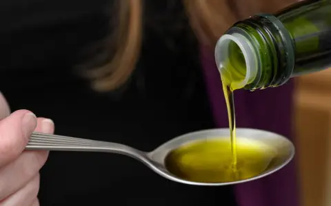 Olej lniany wylewany na łyżkę. Czy olej lniany obniża cholesterol? To pytanie nurtuje wiele osób dbających o zdrowie.