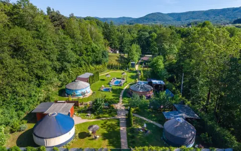 Malowniczy aloha glamp z jurtami, basenami i zielonymi wzgórzami w tle. Idealne miejsce na relaks.