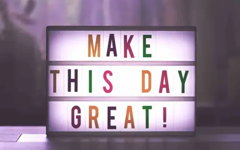 Świecąca tablica z napisem "MAKE THIS DAY GREAT!" dodaje motywacji do pracy.