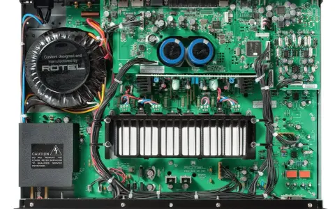 Wnętrze wzmacniacza Rotel A14 MKII z dużym transformatorem i zieloną płytką drukowaną.