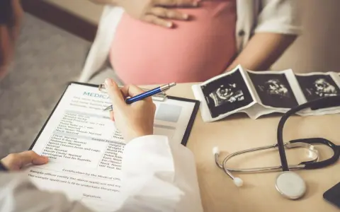 Medico compila cartella clinica con ecografie e stetoscopio. L'autismo si può diagnosticare in gravidanza, con controlli precoci.