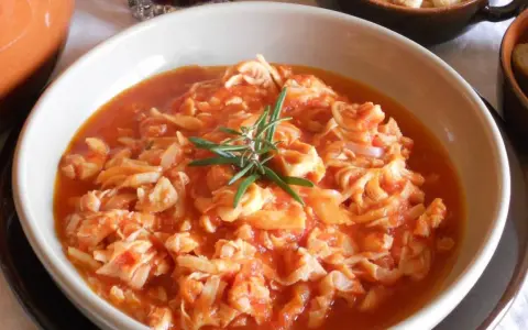Trippa ricetta della nonna in un piatto bianco, guarnita con rosmarino. Un classico sapore di casa.
