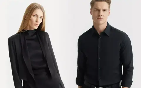 Elegancka kobieta w czarnej stylizacji i mężczyzna w czarnej koszuli. Jakie spodnie do czarnej koszuli? Klasyka zawsze w modzie.