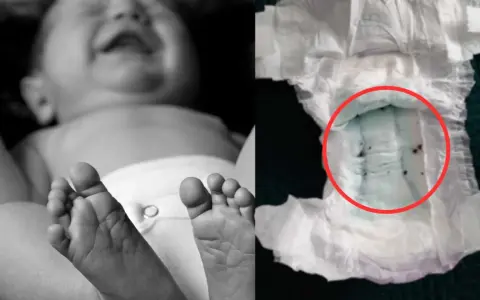 Jak założyć pampersa chłopcu? Zdjęcie pokazuje stopy dziecka i zużytą pieluchę z zielonym wkładem i ciemnymi grudkami.
