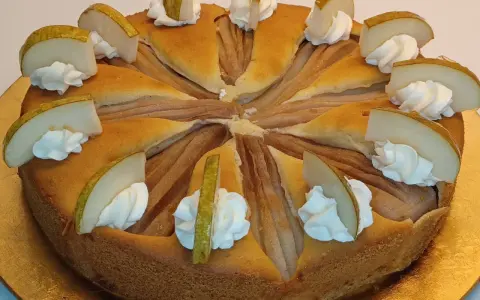 Ein köstlicher Birnenkuchen, verziert mit Sahnetupfern und frischen Birnenspalten. Perfekt für ein Birnenkuchen Rezept.
