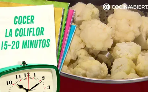Coliflor cocida en una olla, con un reloj y un cuaderno que indica el tiempo de cocción de la coliflor: 15-20 minutos.