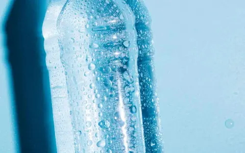 Krople wody na plastikowych butelkach, sugerujące, czy można zamrozić wodę w butelce plastikowej.