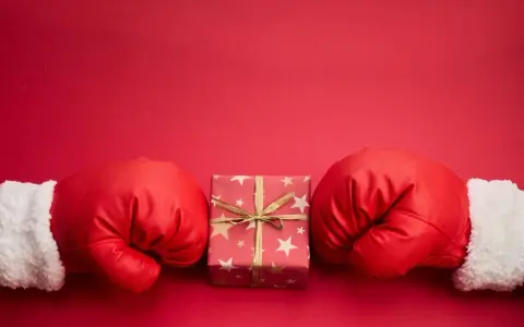 Rękawice bokserskie w świątecznym stylu otaczają prezent. Czy to zapowiedź, boxing day co to znaczy?