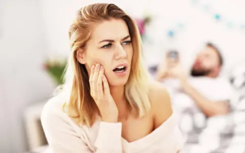 Kobieta z odrętwiałą twarzą po wizycie u dentysty.