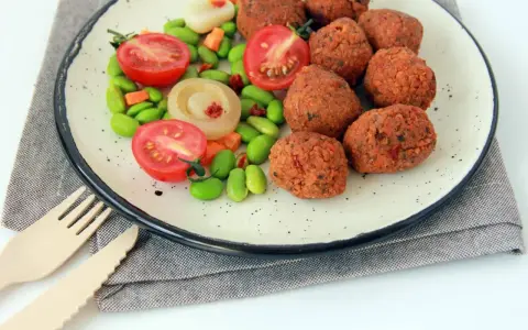 Falafel kontra kotlety sojowe: kulki z ciecierzycy i warzywa na talerzu.