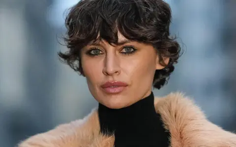 Eine Frau mit einem modernen Fade Cut und einem Pelzmantel.