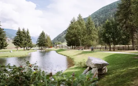 Passeggiata in bici ai laghetti di San Leonardo, tra alberi e montagne.