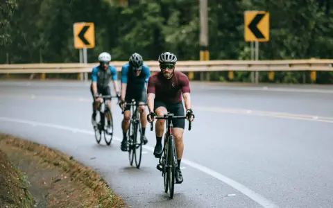 Cyclists on a wet road, navigating curves, embodying the stress recovery adaptation cycle.