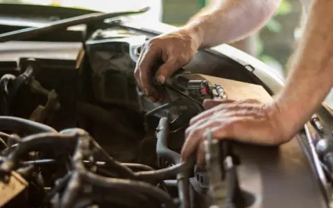 Mecánico revisa el motor de un coche. El sonido de aire al acelerar el coche podría ser un problema.