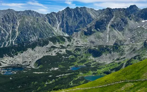 Tatry widziane z trasy turystycznej. Jeziora w dolinie, skaliste zbocza i zielone hale zachęcają do odkrywania piękna Zakopanego.