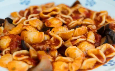 Orecchiette alla tarantina con melanzane e pomodoro, un piatto ricco e saporito.